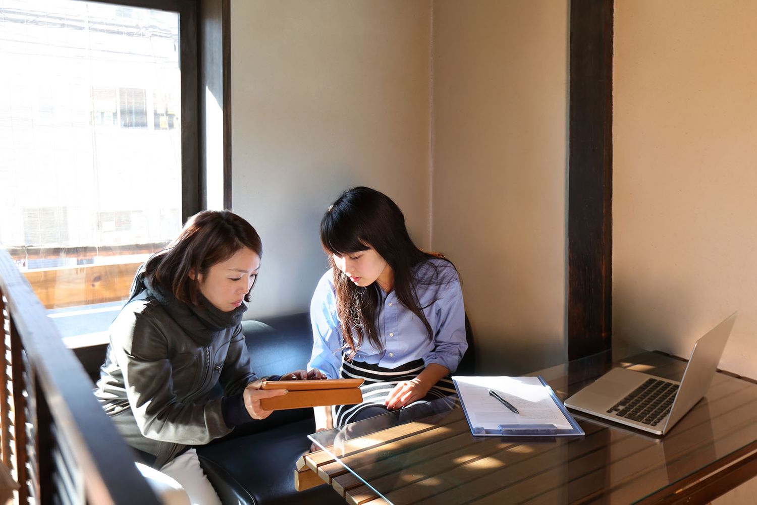 Два человека сидят за кабиной и смотрят на планшет